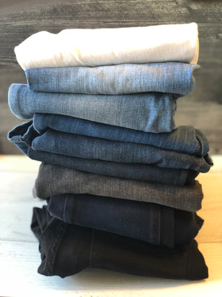 stack of jeans from white to black