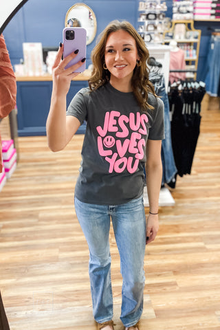 Charcoal Comfort Colors Jesus Loves You Smiley Puff Tee by Poppy & Pine with hot pink puff ink lettering
