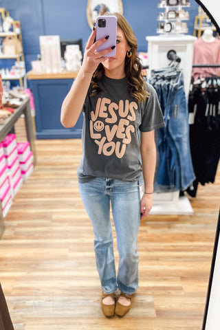 Charcoal Comfort Colors Jesus Loves You Smiley Puff Tee by Poppy & Pine with tan puff ink lettering