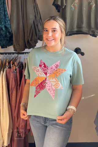 Model wearing the Poppy & Pine Bandana Pinwheel Cropped Tee in sage green with a pink, orange and burgundy paisley quilt star graphic