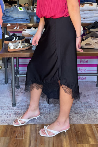 Black satin midi skirt showing the pointed handkerchief hem and lace trim, style SKS16677