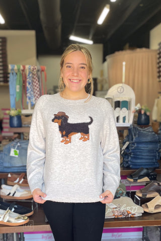 ee:some cowboy dachshund graphic sweater SH17268, front view with hands at the hem, styled with Judy Blue Black Bootcut Jeans JB881184 and Corkys Footwear Black Whats The Rush wedge shoes