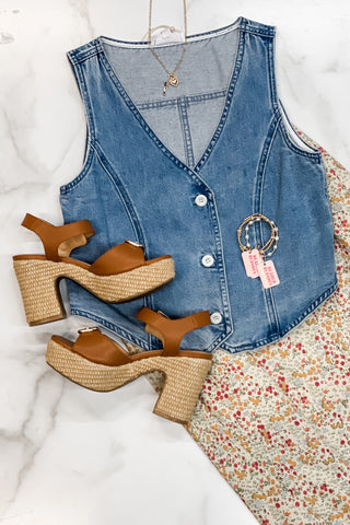 flat lay photo of skirt with Daddys Money sandals and denim vest plus some jewelry