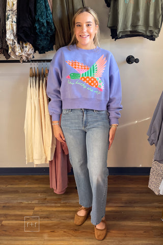 Model standing in the Poppy & Pine How Ducky Are We purple patchwork mallard crop sweatshirt, styled for a casual fall look