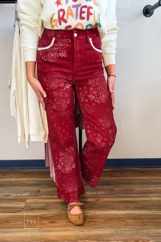 Front view of Poppy & Pine red paisley bandana high rise jeans with lace-trimmed pockets and raw fray hem