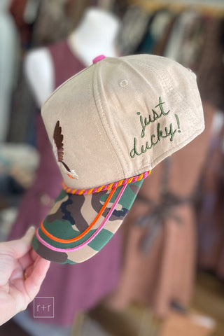 Side view of camo baseball cap with "just ducky!" script and pink and orange trim