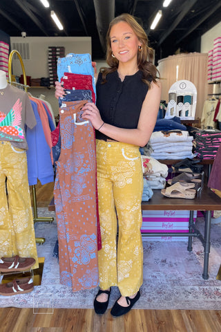 Model holding Poppy & Pine paisley bandana fray hem jeans in brown, navy red and light blue while wearing the mustard pair