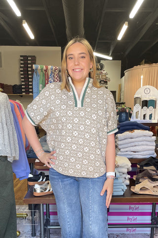 Woman wearing the Umgee taupe jacquard floral top C6449 with a split v-neck and green and cream contrast trim, styled with Risen cropped wide leg jeans.