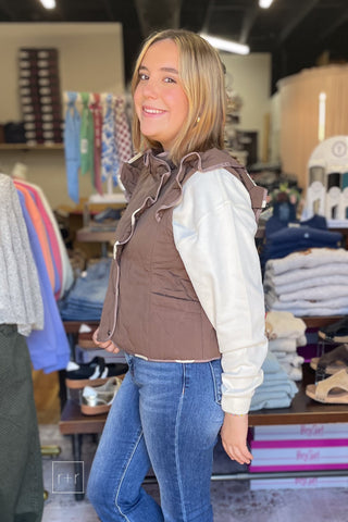 Side view of the Umgee C6829 reversible mocha quilted ruffle vest with the Wishlist Howdy graphic sweatshirt and Risen High Rise Flare Jeans