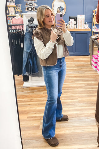 Full-length mirror view of the Umgee C6829 mocha quilted ruffle vest styled with the Wishlist Howdy graphic sweatshirt and Risen High Rise Flare Jeans PF21438