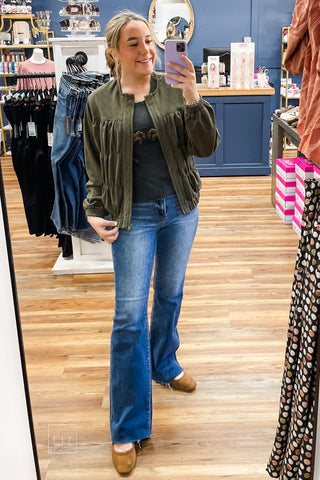 Mirror selfie of the full outfit: Umgee Shayla olive suede-look zip up jacket N7068 with the Double Horses Cropped Graphic Tee, Risen High Rise Flare Jeans, and Corkys Layover Ballet Flats