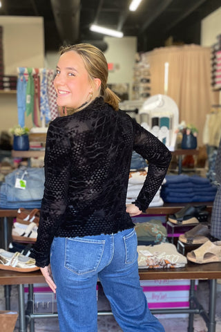 Over-the-shoulder back view of the Umgee D1256 black velvet burnout mock neck top worn with Risen High Rise Wide Leg Jeans