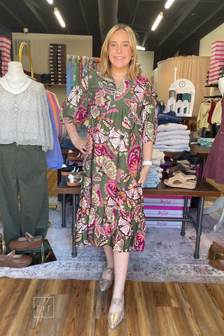 Model wearing the Umgee olive paisley midi dress K0645 in a size Small, showing the tiered skirt and fall floral print, with Corkys Knot Gonna Happen gold mules.