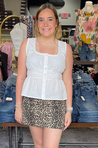Wishlist off white cotton lace trimmed sleeveless peplum blouse WL25-11887 paired with denim leopard print skirt front view