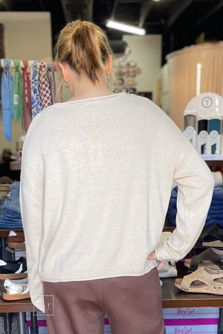 Back view of the Wishlist Scarf Teddy Bear Graphic Knit Sweater (WL26-13104), styled with Eesome Pleated Elastic-Back Waist Wide Leg Trousers in mocha latte brown