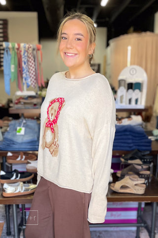 Side view of the Wishlist Scarf Teddy Bear Graphic Knit Sweater (WL26-13104), styled with Eesome Pleated Elastic-Back Waist Wide Leg Trousers in mocha latte brown and Corkys Layover ballet flats in camel